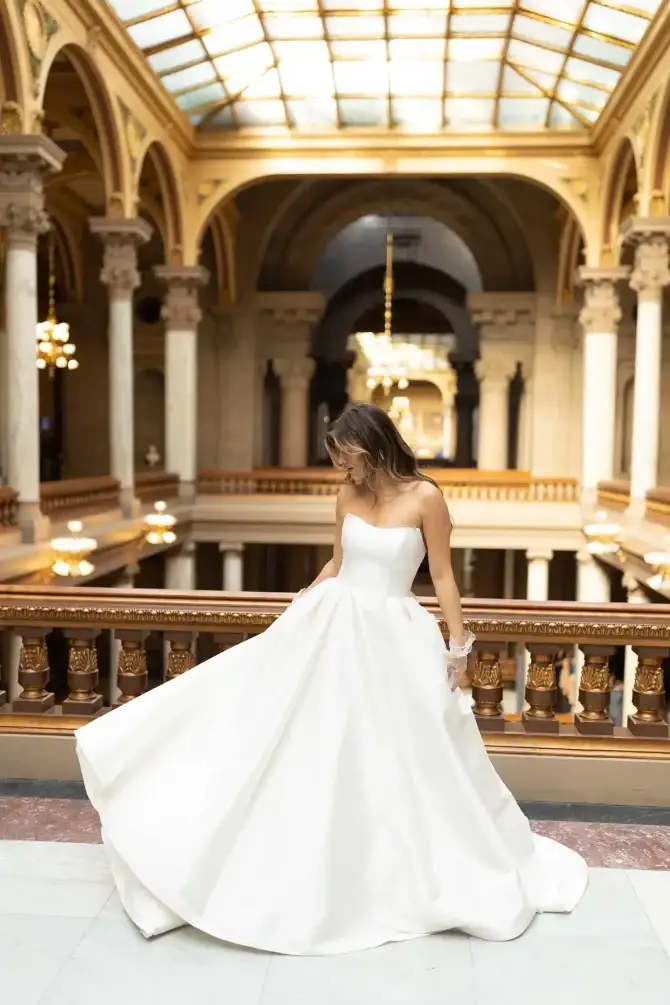 model is wearing a strapless ball gown wedding dress