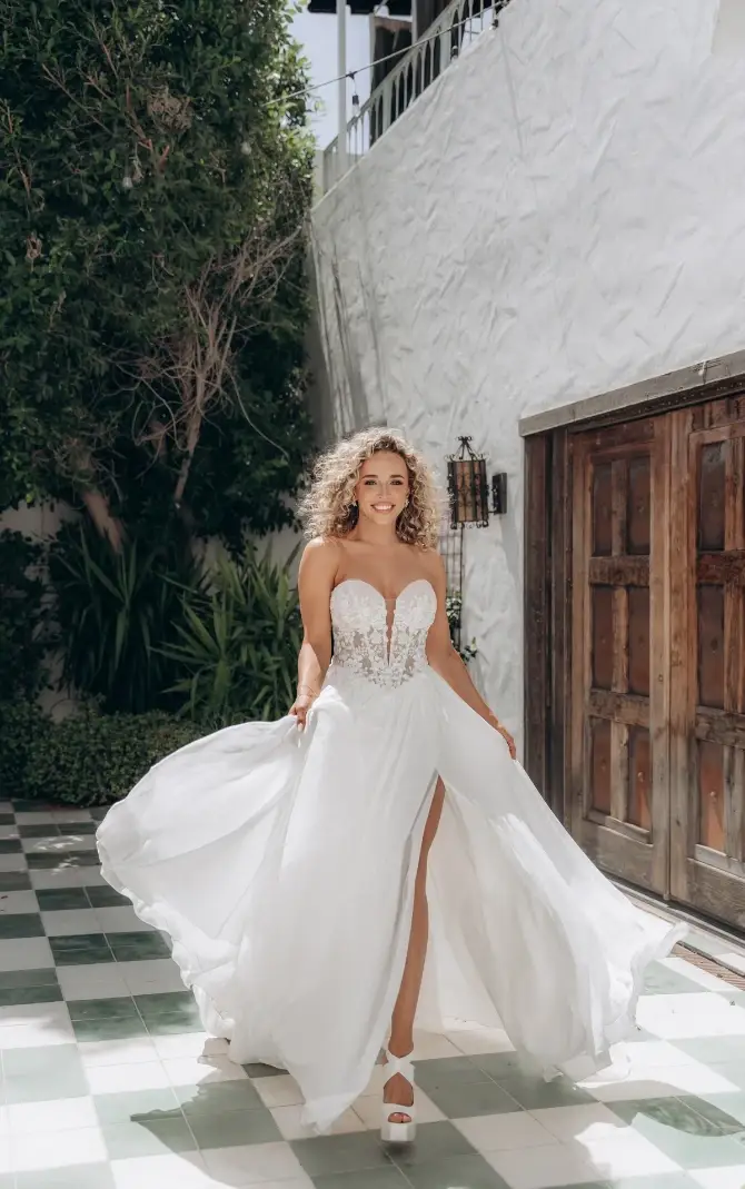 model is wearing a strapless a-line wedding dress with a slit