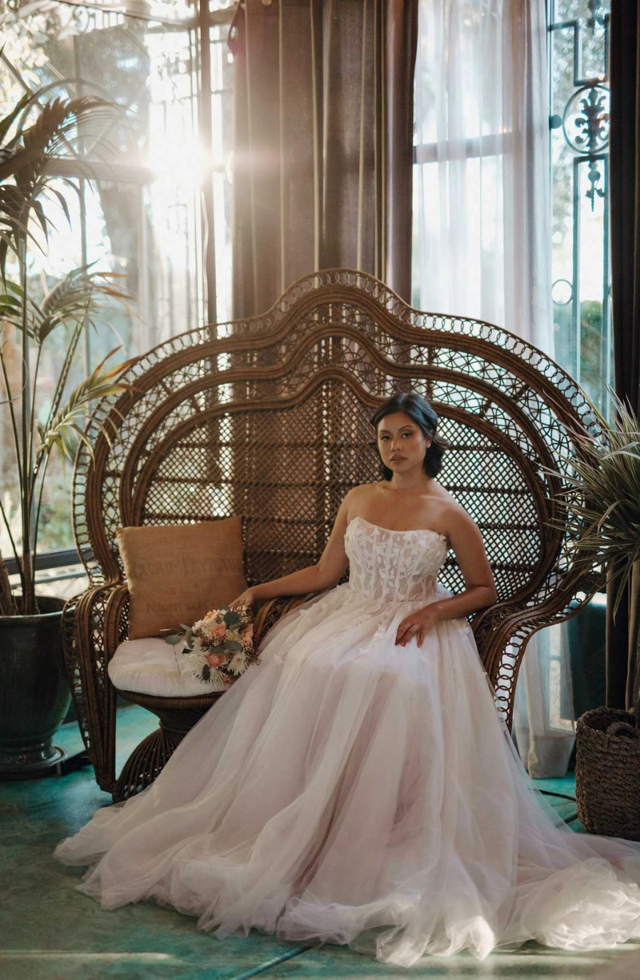 Model is wearing a strapless a-line wedding dress with a tulle skirt and embroidered bodice