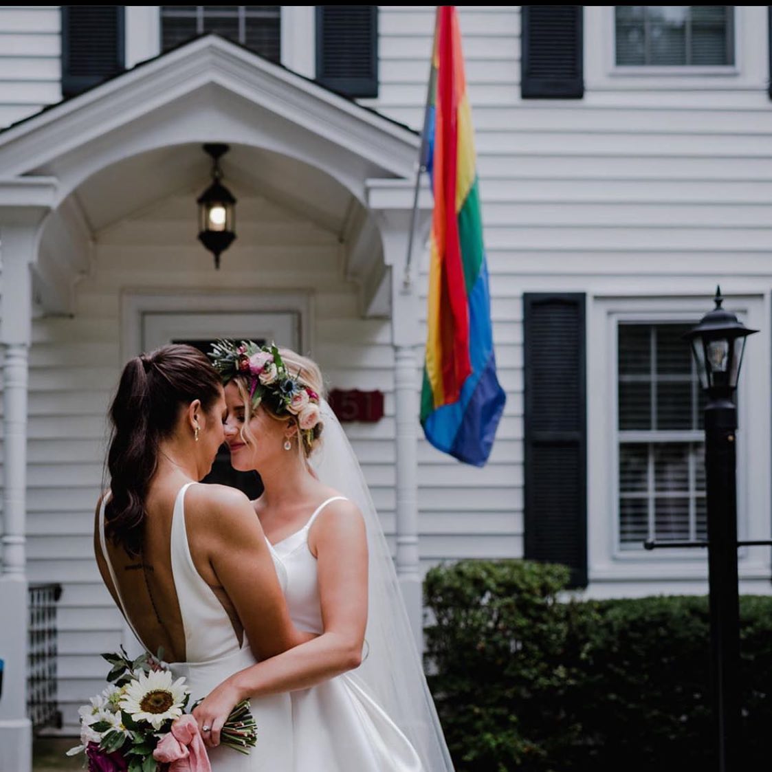 Photo of the smiling real brides near the house